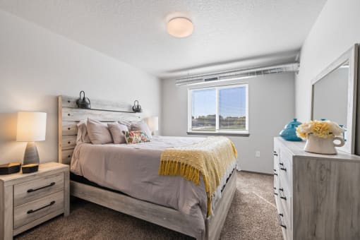 Bright, vacant bedroom with neutral walls and carpet flooring.