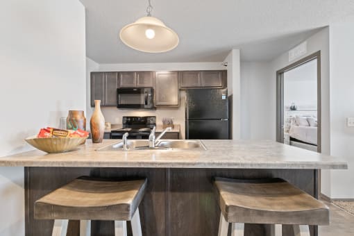 Spacious, combined kitchen and living room with breakfast bar seating.