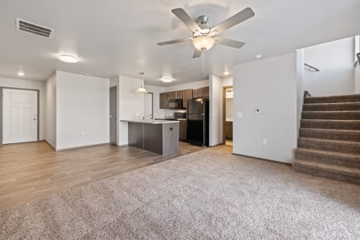 Modern open-concept kitchen and living area with black appliances.