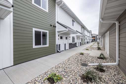 A row of houses with a gravel area in the foreground.
