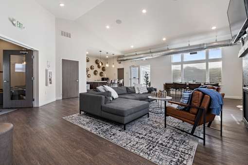 A living room with a grey couch and a wooden chair.
