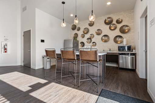 A kitchen area with a dining table and chairs.