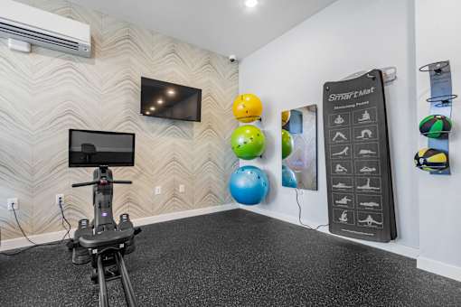 A room with a wall-mounted television, a Smart Mat, and a hoverboard.