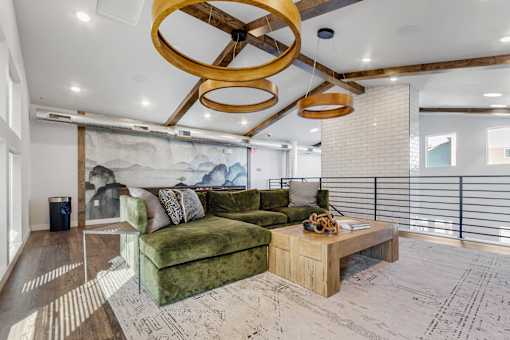 A living room with a green couch and a wooden coffee table.