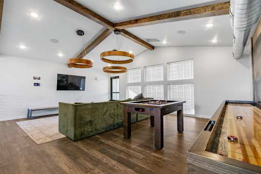 A room with a pool table and a green couch.