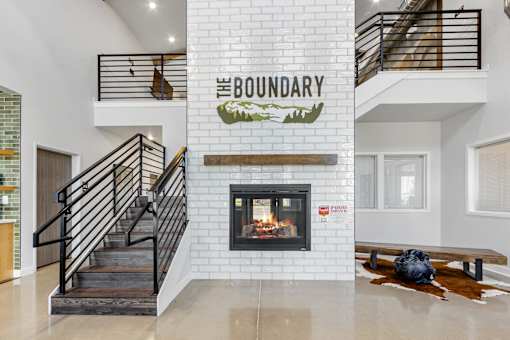A modern living room with a fireplace and a staircase.