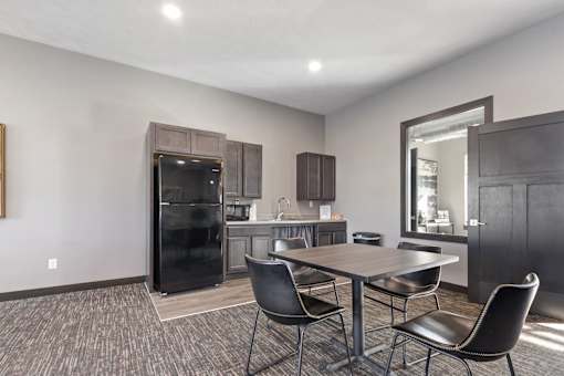 A modern kitchen with a dining table and chairs.