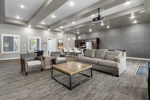A spacious living room with a grey sofa, a wooden coffee table, and a television.