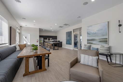 A modern living room with a wooden dining table and grey sofa.