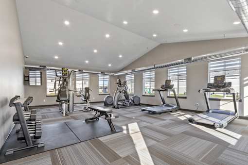 A spacious gym with a variety of equipment including treadmills, weights, and exercise machines.
