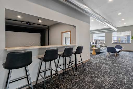 A room with a bar and chairs.