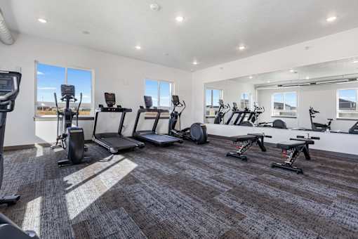 A spacious gym with treadmills, elliptical machines, and other exercise equipment.