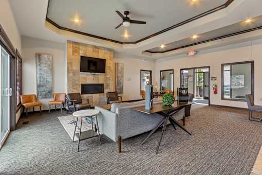 A living room with a stone fireplace and a grey sofa.