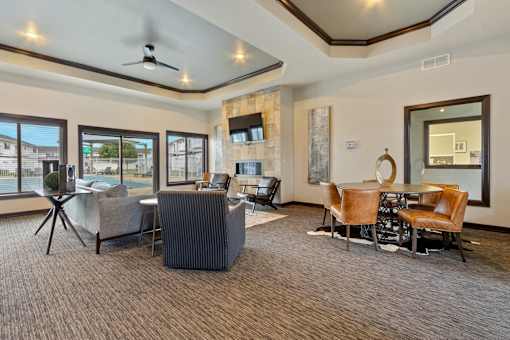 A living room with a grey carpet and brown chairs.