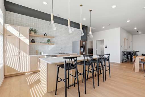 A kitchen with a bar area and chairs.