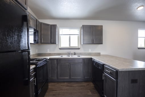 Modern open-concept kitchen and living area with black appliances.