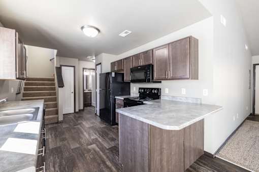 A kitchen with a black fridge and microwave.