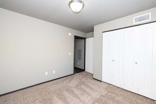 A room with a carpeted floor and a white door.