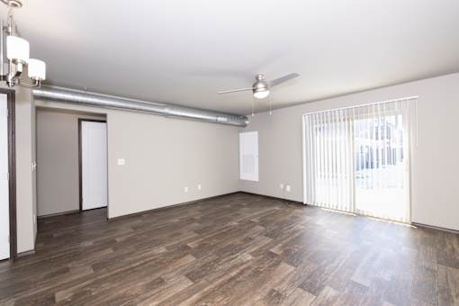 A room with wooden flooring and a ceiling fan.