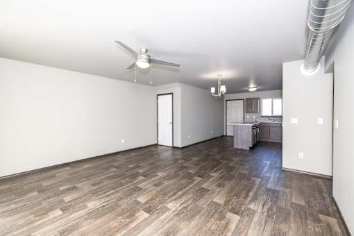 A room with a ceiling fan and wooden flooring.