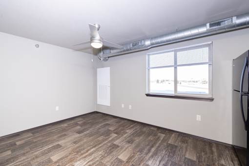 A room with a window and a fan on the ceiling.