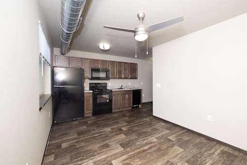 A kitchen with a black fridge, microwave, and stove.