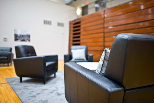 A black leather couch sits in a room with other black leather furniture.