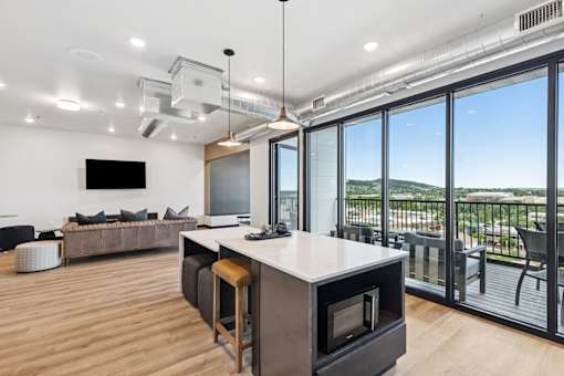 A modern kitchen with a large island and a view of the outdoors.
