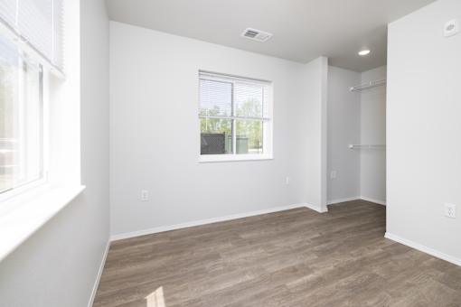 A room with a window and a wooden floor.