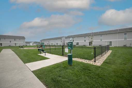 A grassy area with a fence and a sign that says "H" on it.