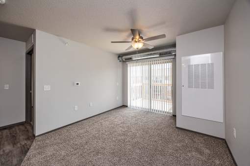 A room with a ceiling fan and a window with blinds.