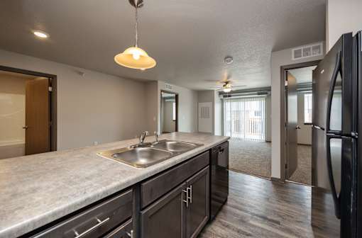 A kitchen with a sink and a refrigerator.