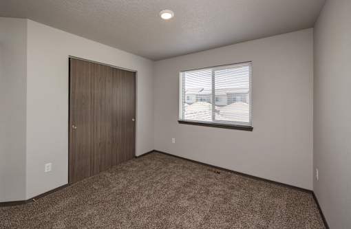 A room with a brown carpet and a brown door.