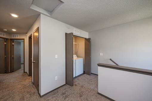 A room with a white wall and a brown carpet.