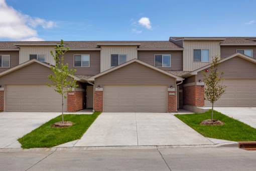 A row of houses with garages and driveways.
