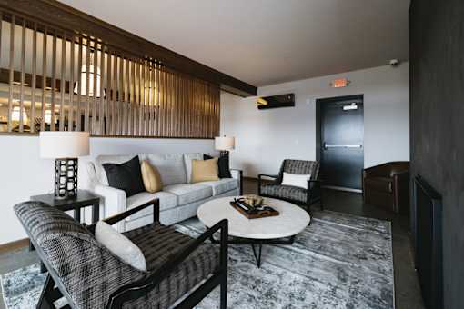A living room with a grey rug and a white couch.