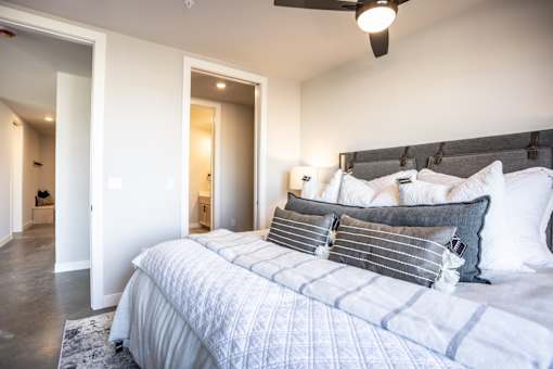 A bedroom with a large bed and a ceiling fan.