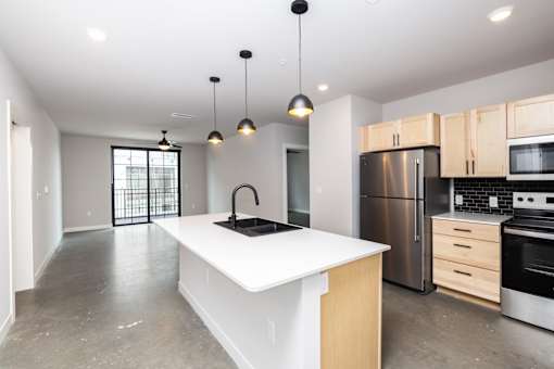 A modern kitchen with a white island and stainless steel appliances.