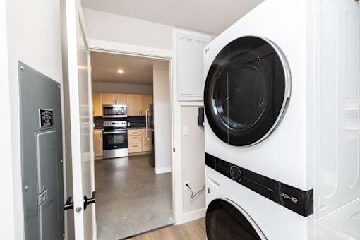 A white washing machine is in a kitchen.