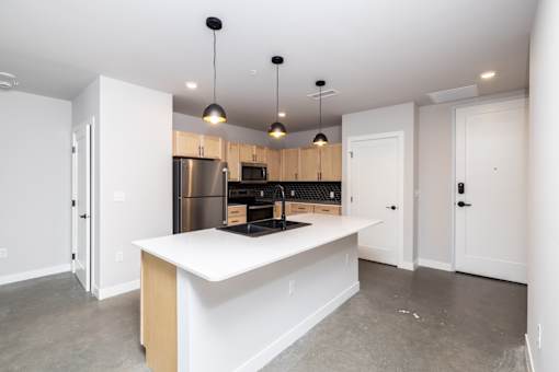 A kitchen with a white island and wooden cabinets.