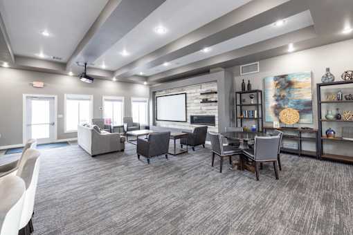 A spacious room with grey carpeting and furniture.