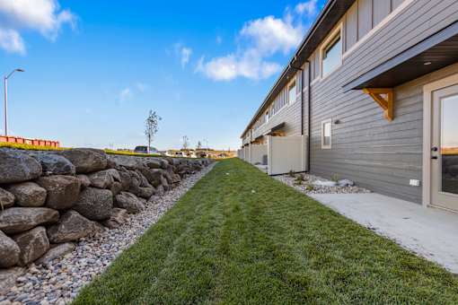 A row of houses with a stone wall in the foreground.