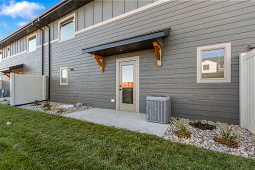 A grey house with a white door and windows.