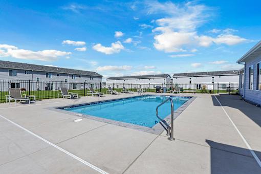 A swimming pool in a sunny outdoor setting.