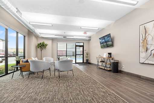 A room with white chairs and a brown carpet.
