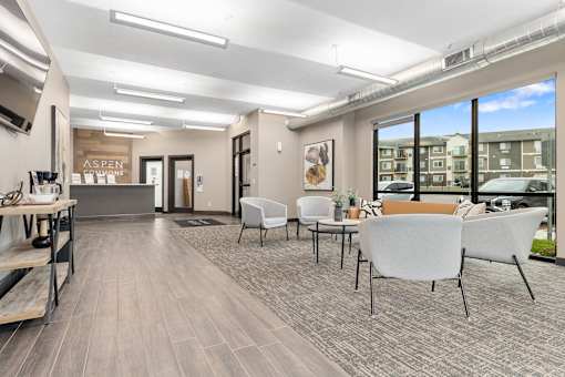A spacious waiting area with white chairs and a wooden floor.