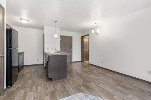 A kitchen with a refrigerator, sink, and cabinets.
