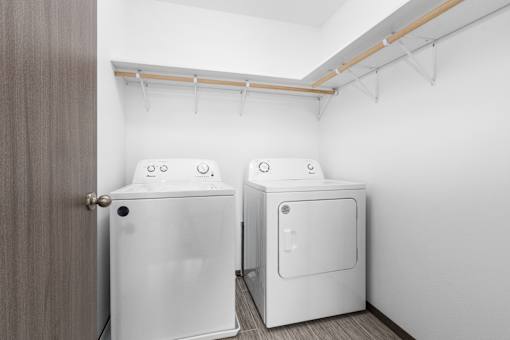 Two white washing machines in a laundry room.
