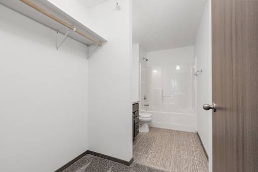 A white bathroom with a toilet, sink, and mirror.