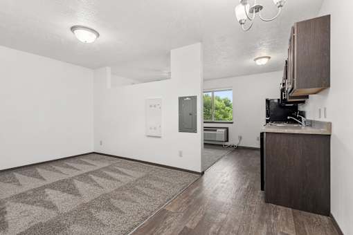 A spacious room with a patterned carpet and a wooden cabinet.